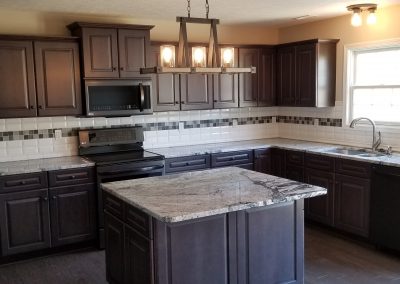 The kitchen in a new home showing the wooden cabinets and tile backsplash.