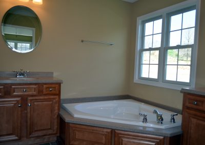 Master bathroom with tub and sinks